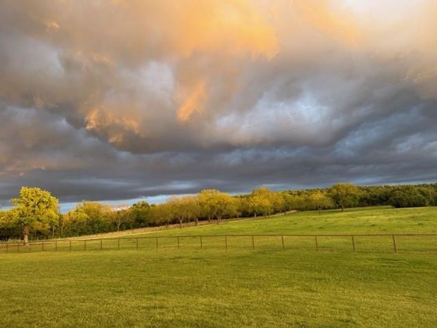 66-Acre Recreational Ranch, Palo Pinto County, Texas.

Parks Ranch is a thoughtfully developed 66-acre recreational property in Palo Pinto County, Texas, located approximately one hour west of Fort Worth. This versatile ranch offers an exceptional blend of productive pasture, scenic terrain, and recreational amenities, ideal as a full-time residence, weekend retreat, or income-producing VRBO property.

Approximately 15 acres of established Coastal Bermuda grass support annual hay production, while the remaining acreage spans rolling elevations with roughly 100 feet of elevation change. The land features native grasses and trees, numerous stately pecan trees, a seasonal creek, a stocked pond, and an extensive network of hiking and riding trails suitable for foot, horseback, or four-wheelers.
 
Developed over twelve years by the current owner, the ranch is fully perimeter-fenced and cross-fenced. The home site encompasses approximately five acres enclosed with no-climb pipe fencing and includes multiple stalls, tack and grooming areas, equipment storage, a 10’ x 50’ shipping container, two electrical RV hookups, improved access drives, and open pasture well suited for livestock or equestrian use. Ag-exempt. Additional outdoor amenities include a garden area, playground, zip line, firepit, and park-like creek bed.

Recreational highlights include a maintained shooting lane, designated wildlife feeding areas, and a luxury elevated observation blind positioned to capture frequent wildlife activity and expansive views across the ranch.

At the heart of the property is a 2,862 sq ft modern farmhouse barndominium offering privacy and sweeping views from a 60-foot covered front porch. The residence features three bedrooms, two bathrooms, multiple living areas, and an attached three-car garage with additional covered parking. Outdoor living is complemented by a six-bench swing gazebo with a propane fire pit...an ideal setting for sunset views.