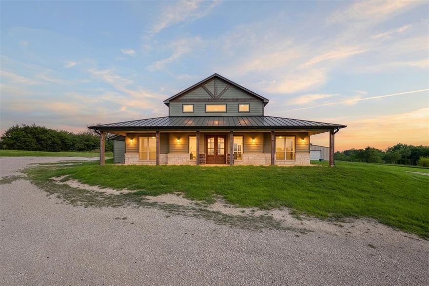 Set on 12 beautiful acres, this custom built home offers the perfect blend of space, style, and country living. The main residence offers 3,479 square feet, plus an additional 440 square feet featuring two bedrooms with a jack and jill bath perfect for an in law suite, guest quarters, or versatile flex space. The open concept design showcases soaring ceilings, striking custom wood beams, and a spacious living area anchored by a floor to ceiling stone fireplace. The kitchen offers abundant cabinetry, granite countertops, stainless steel appliances, and a large island perfect for entertaining. Each bedroom features direct access to the backyard, creating seamless indoor outdoor living and filling the home with natural light. The primary suite includes a spa like bath with an oversized walk-in shower, soaking tub, dual vanities, and ample storage. Outside, enjoy wide open views, a covered patio, and plenty of space for livestock, recreation, or future improvements. A shop building on the property provides additional flexibility for storage, hobbies, or workspace. A rare opportunity to own a thoughtfully designed home with acreage, privacy, and versatility.