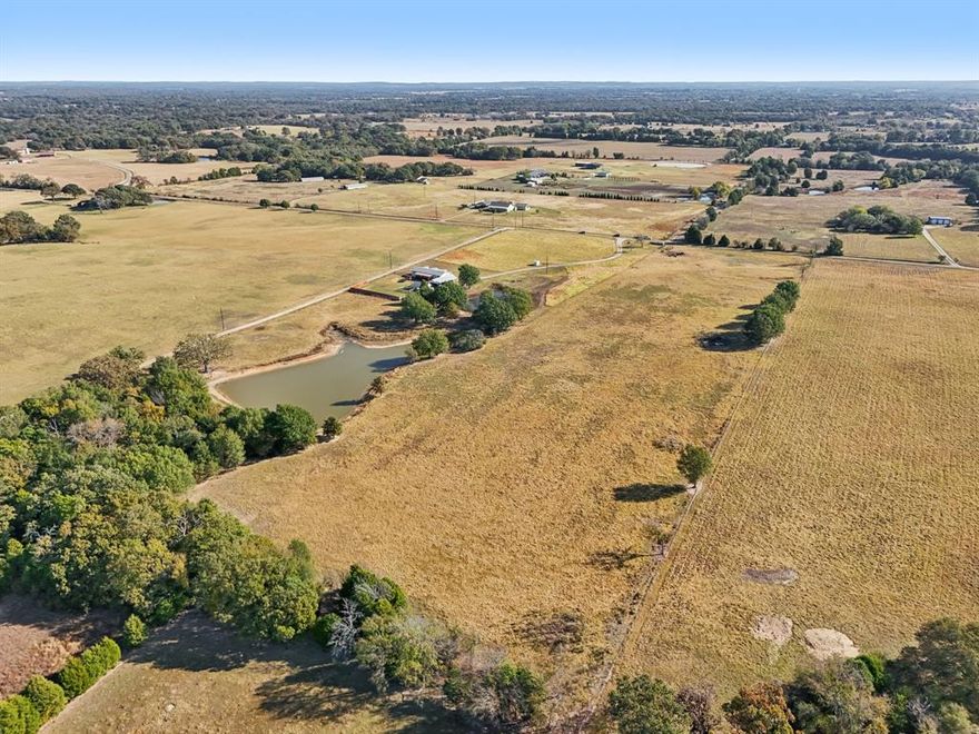 Spacious double-wide on nearly 20 acres featuring an open living, kitchen, and dining layout with a wood stove. Kitchen offers an island, glass cooktop, oven, microwave, and large walk-in pantry. Private split master suite includes a huge walk-in closet with bathroom access, dual vanities, jacuzzi tub, and separate shower. Additional bedrooms include a bunk-room style room with walk-in closet and a generous guest bedroom, plus a hall bath with tub-shower. Separate laundry room with space for full-size fridge or freezer and deck access. Enjoy the 30x10 covered decks on both the front and back, a fenced backyard with privacy fence, storm shelter, and whole-house propane generator. Property also includes upgraded underground electric, aerobic septic system, and a newer HVAC (approx. 3 years old).