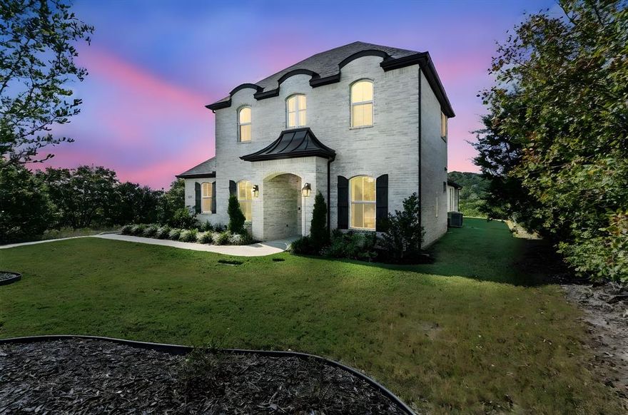Nestled in the heart of Cleburne, TX, this custom-built French-style residence epitomizes luxury living with its sophisticated design and meticulous attention to detail. Boasting 4 bedrooms and 3 baths, this elegant home combines classic charm with modern conveniences.
Step inside to discover a kitchen designed for culinary perfection, featuring granite countertops, a large island, and soft-close cabinets and drawers. The living room offers a cozy atmosphere enhanced by an electric-start fireplace and a state-of-the-art surround sound system that extends to the primary suite, back patio, and upstairs room. The primary bedroom is a haven of relaxation with ample space and a private bath featuring frameless shower doors. A dedicated reading room with built-in bookshelves invites you to unwind with your favorite novels, while upstairs, the carpet is specifically chosen for its water, stain, and pet-proof qualities. A custom-built office desk with shelves provides a functional workspace, making this home ideal for both relaxation and productivity. The media room elevates entertainment with a fully equipped wet bar, complete with a dual-temperature beer and wine cooler, ensuring the perfect pour every time. Stainless steel appliances and modern touches throughout the home integrate seamlessly for a sophisticated lifestyle. Step outside to enjoy the oversized back patio, where you can immerse in the tranquility of breathtaking views and privacy. The exterior of the home features custom iron French doors and white and grayish painted brick, while the landscape boasts a drought-resistant lawn, maintained effortlessly by a Rain Bird sprinkler system. An oversized 2-car garage complements the design, offering ample storage space. Security and efficiency are prioritized with a whole-home security system and tankless water heater. This residence is a sanctuary of style, comfort, and unmatched luxury, offering a unique opportunity to experience the finest in Cleburne living.