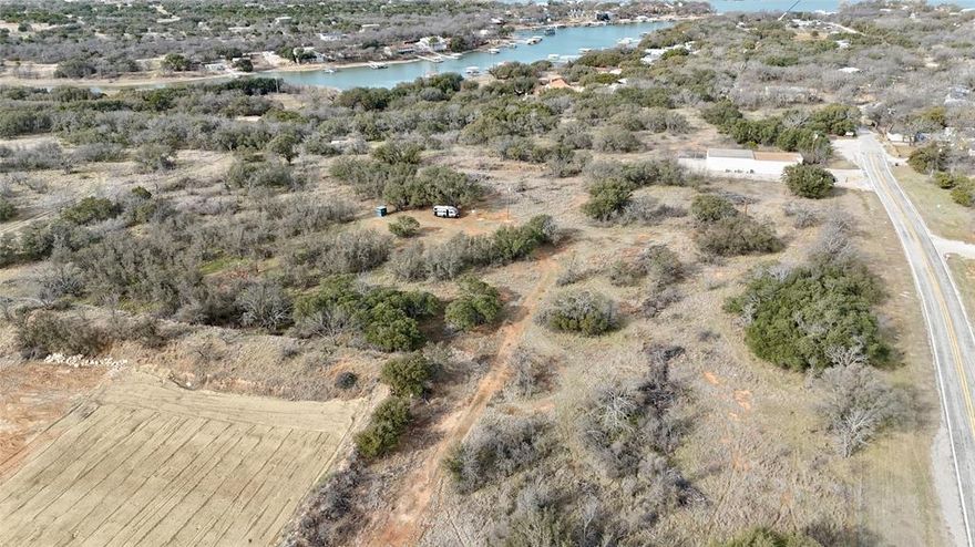 Beautiful 5 + or - Acres located just minutes from the Flat Rock boat ramp and day use park on Lake Brownwood, offering quick and convenient access to boating, fishing, and lakeside recreation.This gently rolling property features paved FM road frontage, scattered mature oak trees, multiple potential building sites, with deer and an abundace of wildlife, with partial lake views, partcial new fencing. former woodsman of the world gun range. Electricity is already on site, and water is available. Located approximately 10 to 12 miles from Brownwood and about 70 miles from Abilene, this property provides the perfect blend of peaceful country living with convenient access to town.The Hideout Golf Club and Resort is nearby, offering golf, dining, and amenities. Additional dining options including The Hideout restaurant and Lake Side Bar and Grill are just minutes away.An excellent homesite for your custom build, barndominium, lake retreat, or weekend getaway with lake access only minutes from your driveway. Box Car on the property will be excluded.