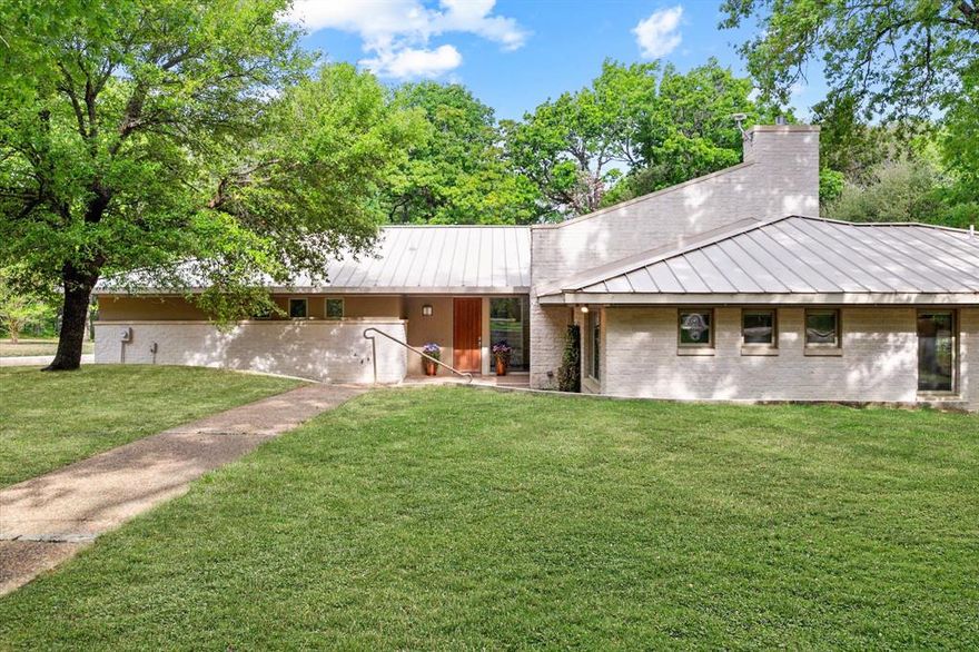 A rare opportunity to own a meticulously designed, energy-efficient lake home with unmatched views, premium construction, and exceptional outdoor living spaces. Experience elevated lakefront living in this stunning contemporary modern home located in the gorgeous Hidden Oaks subdivision on Richland Chambers Lake. Situated on over 1.5 acres with mature trees and 180 ft of shoreline, this exceptional waterfront property offers privacy, space, and breathtaking views from nearly every room. Designed to maximize the setting, walls of windows surround the home and flood the interior with natural light while perfectly framing the lake. The spacious living area features a cozy fireplace and seamlessly flows into the dining and kitchen spaces—ideal for entertaining or simply enjoying the peaceful water views. This thoughtfully designed home offers 3 bedrooms and 2.5 bathrooms, including a primary suite with spa-like features, steam shower, tub and walk-in closet with built-ins. Breakfast area with stunning lake views, formal dining, gorgeous entry way, built-ins in every bedroom, office space for dedicated working area are just a few of the incredible interior features. Built with quality and efficiency in mind, the home includes energy-efficient systems such as all new HVAC, spray foam insulation, and triple-pane windows. Outdoor living is just as impressive, with a large covered patio and an enclosed secondary patio complete with a second kitchen area—perfect for grilling, hosting, and gathering in any season. The property also features a retaining wall and a protected cove setting, enhancing both usability and shoreline stability. Enjoy direct access to the water with a private 2-slip boathouse, offering security and convenience for your boat and lake toys. Additional highlights include a steel studs & frame structure in house, standing seam metal roof, central vacuum system, whole house fan system, built-ins, 3-car garage, and extensive storage throughout.