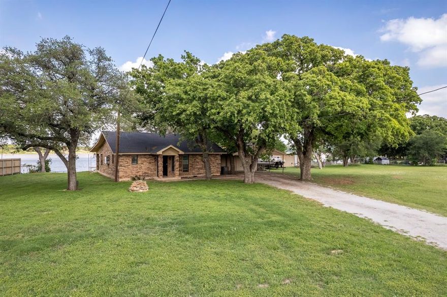 This waterfront lake house offers a great mix of personal use and investment potential. Currently operating as an active, high-performing short-term rental, this 3-bedroom, 1-bath property gives a buyer the option to continue using it as a successful STR or turn it into a comfortable full-time home or weekend place for the family.

The house has a bright, easy layout with open living and dining areas, a functional kitchen, and comfortable bedrooms that work well for guests, kids, or everyday living. The interior has been updated and is set up to be both welcoming and practical.

Outside is where this property really stands out. There’s a large covered back porch that gives you plenty of space to sit, relax, and enjoy the lake views, plus a hot tub that makes it even better after a long day on the water. The yard is shaded by mature trees and has plenty of room to spread out, entertain, or just enjoy being outside.

Down at the water, there’s a private dock for boating, fishing, swimming, or just sitting by the lake. There’s also a separate covered area near the shoreline that could be used as a dance floor, lounge space, or gathering area depending on how you want to use it. A 1-car garage adds extra storage for lake gear, tools, or parking.

Whether someone wants a property they can keep running as-is for short-term rental income or a lake house they can make their own for family use, this one gives them that flexibility. It’s a solid waterfront property with a lot to offer. The setting is peaceful and inviting, with mature trees, open green space, and multiple places to gather, relax, and enjoy the water. Properties like this don’t come along often, especially ones that can work equally well as an income-producing rental and a personal lake retreat. It’s the kind of place where buyers can step in and use it right away, while still having room to make it their own over time. 

Come take a look today and make this piece of Texas, YOUR next piece of Texas.
