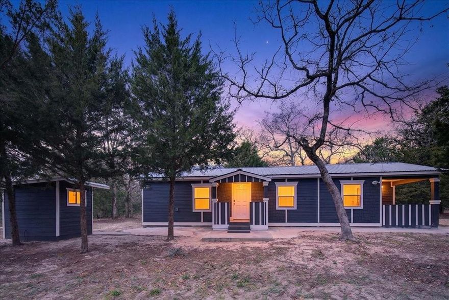 Charming 3-bedroom, 2-bath blue cottage nestled among beautiful pine trees on a peaceful 2-acre property. Built in 2023, this cozy home features an open layout with a private office space conveniently located next to the primary bedroom and a lovely patio perfect for enjoying the surrounding nature. A new AC unit was installed in 2025, adding comfort and peace of mind.

The property offers additional buildings, including one with a full bathroom that could be converted for potential income, guest quarters, a studio, or a workspace. There is also an outdoor storage shed and a dedicated outdoor cooking area—perfect for gatherings and enjoying the country setting. The land is mostly barbed-wire fenced (excluding the front), providing privacy and flexibility for animals or gardening. A beautiful trail begins on the right side of the property, ideal for peaceful walks through the pines. A few crops have already been planted, giving the new owner the opportunity to enjoy the fruits of what’s been started. A quiet countryside retreat with space to grow, create, and make it your own.