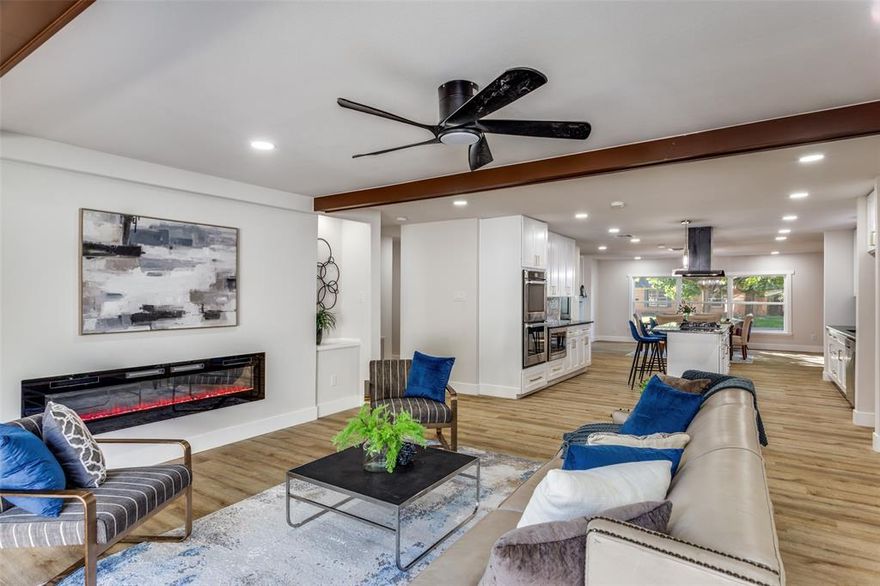 Enjoy bright, modern living in this beautifully renovated home, perfectly situated in close proximity to TCU and Fort Worth's best amenities. Step inside to discover open-concept rooms flooded with natural light from oversized windows, luxury vinyl flooring throughout, and upgraded finishes at every turn. Exposed wood beams add warmth and character to the airy living spaces, while a striking electric fireplace creates an inviting focal point. The chef's kitchen is a showstopper, featuring gleaming quartz countertops, a contemporary gray tile backsplash, stainless steel appliances including a gas range with designer hood, and a spacious island with seating—perfect for entertaining. An oversized walk-in pantry provides abundant storage and organization. The thoughtful layout seamlessly connects the kitchen, dining area, and living room, creating an ideal flow for both everyday living and hosting guests. Throughout the home, modern fixtures, recessed lighting, and designer touches elevate the space. Outside, relax in the privacy-fenced backyard shaded by mature trees, while a rare 4-space covered carport plus detached 2-car garage provides plentiful protected parking options. An unfinished space in the backyard presents exceptional potential—creating an accessory dwelling unit, guest house, or rental suite for income or multi-generational living adding 375 Sqft. This move-in-ready property combines excellent location, privacy, stylish contemporary finishes, and a value-added income opportunity, making it perfect for both comfort and future growth. Don't miss this gem in a sought-after Fort Worth neighborhood!