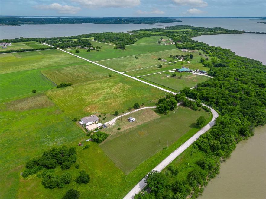 This property 9.99-acre property with home and shop has an incredible view of the North-West arm of Lake Ray Roberts. Enjoy evenings sipping wine on your front porch, watching the best sunset North Texas has to offer - it doesn't get much better than that. Edge of the Lake Vineyard is less than half a mile from the property - a quick golf cart ride to enjoy fine wine and a charcuterie board. If you enjoy boating or fishing, you are just 3 miles from the boat launch for Lake Ray Roberts and 6 miles from the state park for hiking & mountain bike trails. New roof installed 2022, luxury vinyl plank flooring installed in 2022, and interior repainted in 2022.  Nice 40 X 30 insulated shop with 2 car carports in front of shop.  Possible owner financing at 8% interest rate.