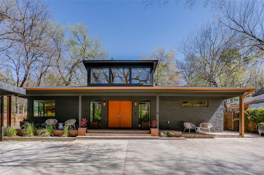 Tucked along one of Oak Cliff’s most enchanting tree-lined streets, this exquisitely reimagined mid-century residence feels both quietly sophisticated and effortlessly livable. Set on a rare 0.38-acre creekside lot on Ravinia Drive, the home unfolds as a private retreat where architecture, nature, and thoughtful design converge. Inside, light moves freely through an open, gallery-like interior where vaulted ceilings, smooth-finish walls, and warm hardwood floors establish a refined yet inviting atmosphere. The living spaces center around a vintage Preway fireplace, creating an intimate focal point for evenings of quiet comfort or relaxed entertaining. The kitchen is both chic and functional—anchored by honed marble countertops, a generous island, and premium appliances —offering a space equally suited for everyday living or elevated gatherings. Taken down to the studs in 2020, the home’s meticulous renovation is felt throughout where every finish was curated with intention. Modern systems—including updated electrical and plumbing, spray-foam insulation, and a recently replaced roof, windows, HVAC, and water heater—ensure the home lives as comfortably as it looks.
Outdoors, the property reveals its most enchanting feature: expansive grounds that cascade toward tranquil creek views, creating the rare feeling of a secluded nature retreat within the city. A large welcoming front porch invite morning coffee, al fresco dinners, and long Texas evenings beneath the trees. Located just moments from amenities, the home offers easy access to beloved neighborhood destinations such as the Bishop Arts District, The Kessler Theater, and the scenic trails of the Oak Cliff Nature Preserve—combining architectural character with vibrant urban living.