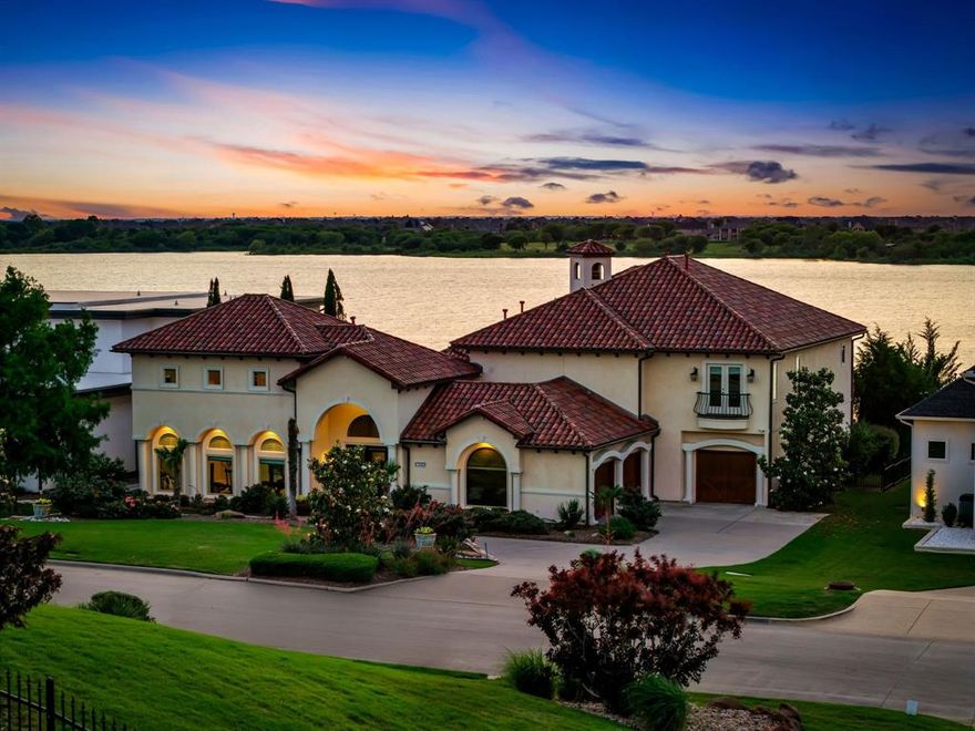Hidden in the exclusive gated community of Waters Edge, this Mediterranean Hacienda-style home sits on Lake Lewisville with incredible scenic views day and night!! Highly desirable community known for its exclusivity and lakefront lifestyle. This custom-build is thoughtfully designed to maximize views and privacy, and is equipped with an elevator! Beautiful landscaping surrounds the circle drive and leads to stately, oversized front doors. Elegance abounds with a spacious foyer for greeting guests showing off travertine floors, a dramatic staircase and soaring ceilings, open to the formal living area with adjacent bar ideal for entertaining, all with lake views from walls of windows! Spacious kitchen features a center island, separate breakfast bar, professional appliances, granite countertops & stunning cabinetry. The neighboring family room has hardwood floors, pool views and built-in entertainment center with doors to the pool&spa with built-in grill station. Primary suite features French doors that open up to stunning lake views, hardwood floors, fireplace, tiered tray ceiling and a serene en-suite bath with built-in cabinets, dual vanities & a jacuzzi tub in front of a large walk-in shower. The covered back patio spans the rear of the home and overlooks the open yard and direct lake access. A separate pool house provides privacy and flexibility, making it an excellent option for a mother-in-law suite or guest retreat. Bonus features include wine cellar, family room bar, exercise room, spacious study and three car garage. Conveniently located north of Dallas, offering easy access to PGA Frisco, The Star, Grandscape, and DFW Airport, while still providing a peaceful sanctuary on the lake, Waters Edge is a private, gated community renowned for luxury homes & lakeside living. Residents enjoy outdoor recreation, boating, and fishing, all while remaining close to premier shopping, dining and entertainment. Thoughtfully designed for everyday living & entertaining!