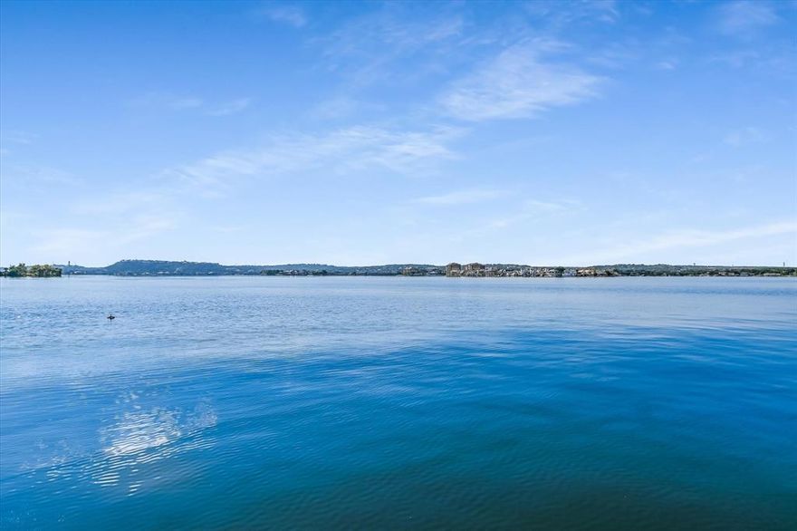 LOCATION LOCATION LOCATION! OPEN WATER ON LAKE LBJ on Iconic Lighthouse Drive. This 5 Bdrm, 5.5 Bath stately home with a rare 3 car garage and parking for up to 11 cars is ideally positioned with North-South exposure. Beautiful open water views from the iron double front doors and massive open water views and direct access to the lake from the back of the house-boat dock-deck. Almost every room in this re-imagined and newly renovated home has a view of Lake LBJ. This home features wide plank engineered hand-scraped wood floors throughout most of the house as well as stone in wet areas and closets, and luxury vinyl flooring in the bunk room and 1bd, 1ba boat house casita. The primary suite features 2 ensuite bathrooms and separate closets and a newly renovated shower. There is a large study off of the entrance and another bonus room off the kitchen & powder room- perfect as another office, hobby room or overflow room for guests. Both bathrooms upstairs have also been renovated with porcelain and quartz. The spacious game room up with wet bar and balcony overlooking lake is shared by two Bdrms, Baths and a bunkroom. There is a newly added turfed area as the side yard, perfect for dogs and ease of cleaning. The outdoor kitchen is off the ovrsz deck is perfect for gatherings, or just enjoying the rays, views, and sunsets. There are 2 hydraulic jet skii lifts and single boat lift. This home is perfect as a full time residence, family lake house, and or a great STR investment opportunity. Come See!