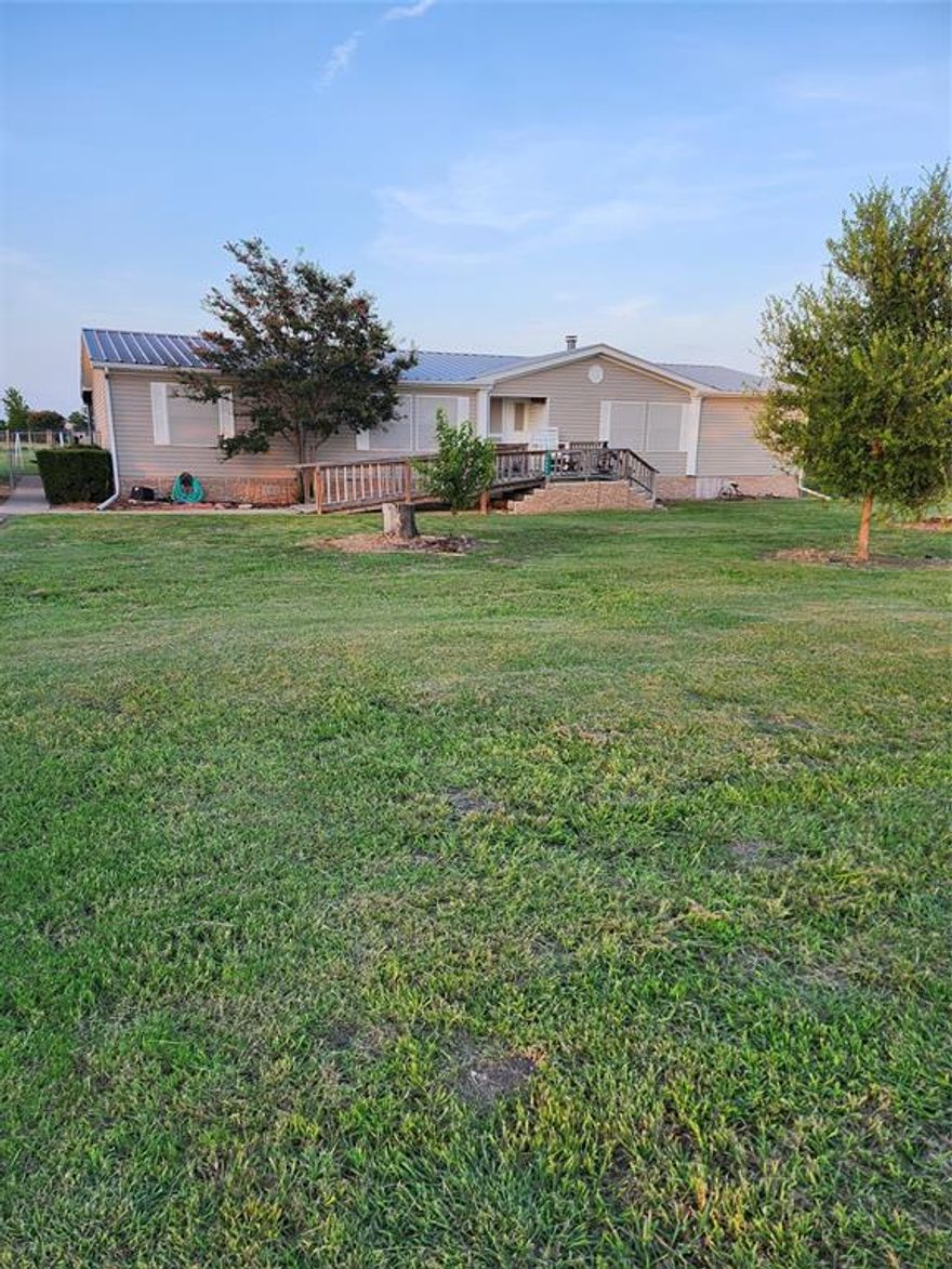 Doublewide on 1 acre of land, 2 car garage 1 covered parking spot attached to garage. Storage building in back yard with chain link fence around back yard. Covered back porch across back of house. Front porch with wheel chair ramp but steps left underneath if want to remove ramp. Detached 2 car garage gravel driveway extra large for parking. House has 3 bedrooms 2 full bathes. 1 bath has a walk in bath tub for handicap persons. Doors have been widened for wheel chair accessibility. 2 dinning areas, living room with fireplace. Pantry in kitchen. Vinyl flooring is 1 year old. House has metal roof put on in April 2017. Garage is 18 by 33 car port is 12 by 30. HVAC unit is 1 year old. Home also has alternate power source that generator can be plugged into on outside of house by power box. There is a surge protector for whole house on outside by power box as well. Also motion senesced lighting on the outside.