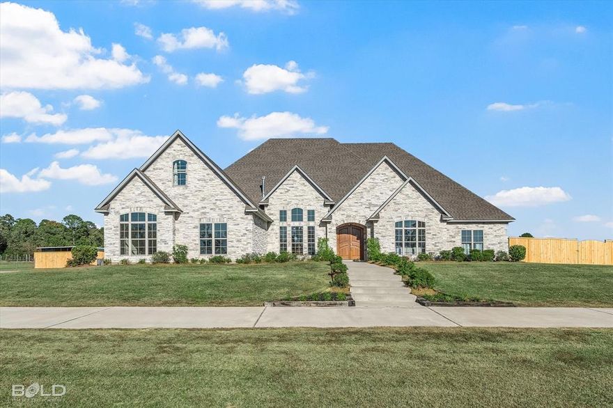 Come find your perfect blend of luxury & spacious country living set on almost 23 acres in north Louisiana. 9480 Mccain isn't just about meeting every need you could find in a property, it's about exceeding it. Set against the rolling hills is a 5,226 sq ft beauty designed for bringing family and friends together. An open floor plan in the living areas boast sight lines between the living, dining, formal sitting, & kitchen. Marble floors adorn the entire downstairs flooring. A spacious living rm designed for comfort features wooden beams spanning all the way to the back with massive windows overlooking the patio & backyard. A Large stone archway separates the kitchen complimenting the exteriors design & craftsmanship. A chef's kitchen with an 8 ft island allows for ample serving space while coupling it with additional storage underneath that also feature an ice machine & microwave. Top of the line appliances with stainless steel, industrial grade oven with gas cooktop, double door built in refrigerator, & copper pot filler & farm sink. Primary suite is quite spacious with private gas fireplace. Custom master bath featuring dual vanities, whirlpool tub, multi shower head shower, & a massive walk-in custom closet. Both guest beds downstairs feature their own private baths, 1 with large soaker tub; 1 with stall shower. Upstairs is the 4th bedrm plus a full stadium style media rm with built-in projector & luxury recliners. Now let's move to the outside. An outdoor kitchen featuring gas grill, sink & refrigerator introduce you to the covered patio. Sprawling patio furniture & a gas fireplace draw your attention to the backyard. Fully fenced in backyard separates the home from the pastures it connects to. One stable on the east side of the property. Multiple pastured areas with multiple gates for ease of access. This allows for the ease to bring your own horses or small herd of cattle on immediately without worry. Make an appointment today and let's find your paradise.