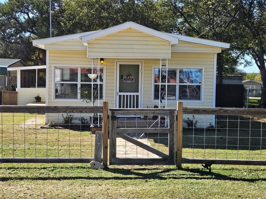 JUST REDUCED!!! This precious home is move-in ready!!! Located on Lake Whitney in Lakeside Village in beautiful Bosque County, TX. Spacious open floor plan, freshly painted, offering two bedrooms, one bath, a metal roof, central air and heat, newer appliances, a stainless steel refrigerator, and a stackable washer and dryer. Enjoy your morning coffee and evening cocktails, gazing at your two small views of the Brazos River from your dining table or your large screened-in, covered deck. This property sits on a large corner lot, features a two-car carport, offers plenty of parking for your guests, and includes a gated parking pad for your boat, camper, and lake toys.  In addition, there’s a nice-sized storage workshop building with electricity. Located with easy access to numerous boat ramps and parks for the fishing and water recreation enthusiasts! An assumable VA Loan at a low 5.75% interest rate, as well as 100% Financing through USDA for qualified buyers. Seller is offering a flooring allowance or concessions for the buyer to use as they wish!