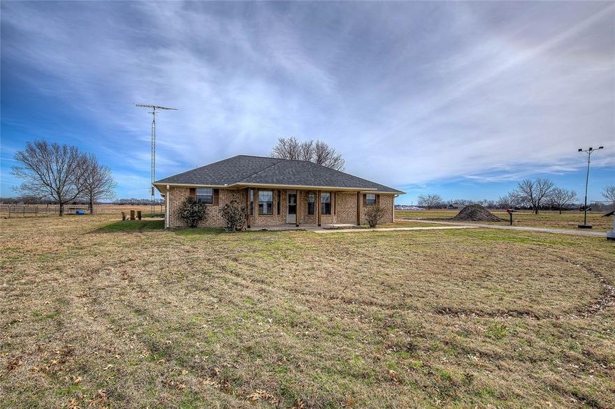 Charming 3-bedroom, 2-bath brick home set on 2.48 scenic acres northeast of Commerce, surrounded by open Blackland Prairie. Built in 1992, the home offers 1740 sq. ft. of interior space plus a 288 sq. ft. enclosed patio, totaling 2,028 sq. ft. of versatile living area. Interior highlights include a warm, country-style design with carpeted bedrooms, a spacious primary suite with dual sinks and a separate shower and bathtub. With large laundry and mud rooms, keep from bringing the outdoors inside to a minimum! Make dinner a breeze with the incredible walk-in pantry built for function. A detached two-car garage with bonus room, outdoor storage shed, and wide-open pasture views provide both utility and charm—ideal for enjoying quiet evenings and vivid sunset skies. Conveniently positioned between Commerce and Greenville, the property offers a peaceful rural setting with quick access to shopping, dining, schools, and the university community.