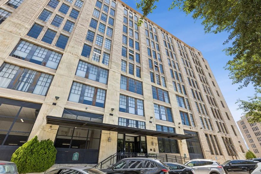 Experience elevated downtown living at 1122 Jackson St #820, a stylish loft residence in the iconic SoCo Lofts building in the heart of Dallas. Originally constructed in 1925 and thoughtfully converted for modern urban living, this spacious 1 bedroom, 1 bathroom residence offers approximately 1,024 square feet filled with character, flexibility, and sought-after industrial design elements. Positioned on the 8th floor, the loft showcases exposed brick walls, soaring ceilings, oversized windows, granite countertops, contemporary cabinetry, updated lighting, and views of the Dallas skyline. The open concept design creates exceptional versatility, featuring two distinct living areas that feel naturally separated despite the expansive loft layout. An additional enclosed flex space offers privacy and can easily function as a bedroom, office, studio, workout space, or creative retreat. Recent improvements include the addition of proper bathroom closets for enhanced storage and organization. Located at the quiet end of the hallway away from elevators and trash areas, this unit delivers a more peaceful atmosphere rarely found in downtown condominium living. Residents of SoCo Lofts enjoy premium amenities including a rooftop pool, rooftop deck with grilling area, fitness center, media center, yoga room, controlled access entry, doorman service, and underground parking garage access. HOA dues include high-speed internet, water, building maintenance, and doorman services, adding convenience and value for owners seeking low maintenance living in an unbeatable location. Just moments from downtown restaurants, entertainment venues, shopping, parks, major employers, public transit, and vibrant nightlife, this residence offers the ideal blend of historic architecture, modern comfort, and walkable city living in one of Dallas' most recognizable loft communities.