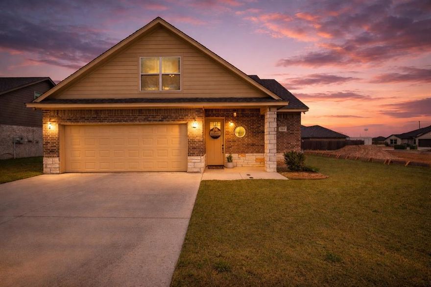 Motivated Seller! Welcome to this like-new home in the highly sought-after Parks of Tolar community — and best of all, no HOA. Built in 2023, this beautifully maintained residence offers 1,611 sq. ft., 3 bedrooms, 2 full bathrooms plus a convenient half bath, with a thoughtfully designed layout ideal for modern living.
The bright, open-concept main living area features tile flooring, recessed lighting, crown molding, and abundant natural light, creating a comfortable space for both everyday living and entertaining. A stone fireplace with wood mantel anchors the living room and adds warmth and character. The kitchen shines with granite countertops, stainless steel appliances, subway tile backsplash, custom cabinetry, and a large island with seating that flows seamlessly into the dining area highlighted by a modern chandelier.
The private primary suite on the main level offers comfort and privacy, complete with an en-suite bath featuring a separate soaking tub, walk-in shower, and generous space. Secondary bedrooms are well-sized with neutral finishes and ceiling fans, ideal for guests, family, or a home office. A dedicated laundry room with built-in cabinetry adds convenience, and the refrigerator, washer, and dryer convey — making this home truly move-in ready.
Step outside to enjoy a covered, screened-in patio overlooking a large, level, fully fenced backyard — perfect for pets, play, or future entertaining. A full sprinkler system enhances the home’s low-maintenance appeal, while the attractive brick and siding exterior provide excellent curb appeal.
Located in Tolar ISD, known for its strong school ratings and welcoming community atmosphere, and conveniently situated approximately 8 miles from Granbury and 21 miles from Stephenville, this home offers the ideal balance of small-town living with easy access to nearby amenities.
Move-in ready, well maintained, and priced to sell — this home is ready for its next owner.