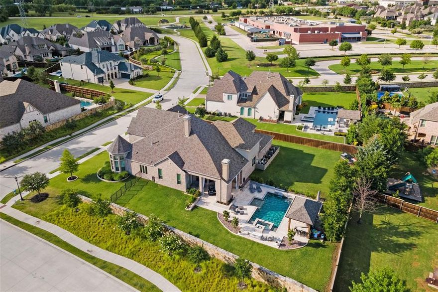 Perfectly situated on a half acre corner lot just steps away from highly acclaimed Cockrell Elementary in desirable Whitley Place, this luxury home has it all! Built by Drees, this magnificent home boasts over 5,300 sq ft of open concept living with 5 bedrooms, 4 full baths, numerous living spaces, an oversized study, media room with wet bar & fridge, huge game room, & a walk in bar area with a wine fridge & a beverage fridge! The kitchen of your dreams with white quartzite countertops, high end appliances, walk in pantry and ample storage. Designer lighting and colors throughout, surround sound audio inside and out, tons of oversized walk in closets, large laundry room, and floor to ceiling windows bring in natural light and views of your backyard oasis from across the back of the entire home. Travertine stone surrounds the sports pool, hot tub, fire pit and outdoor kitchen that dreams are made of! Plenty of green space for the kids & a 4 car garage and gated porte cochere entry.