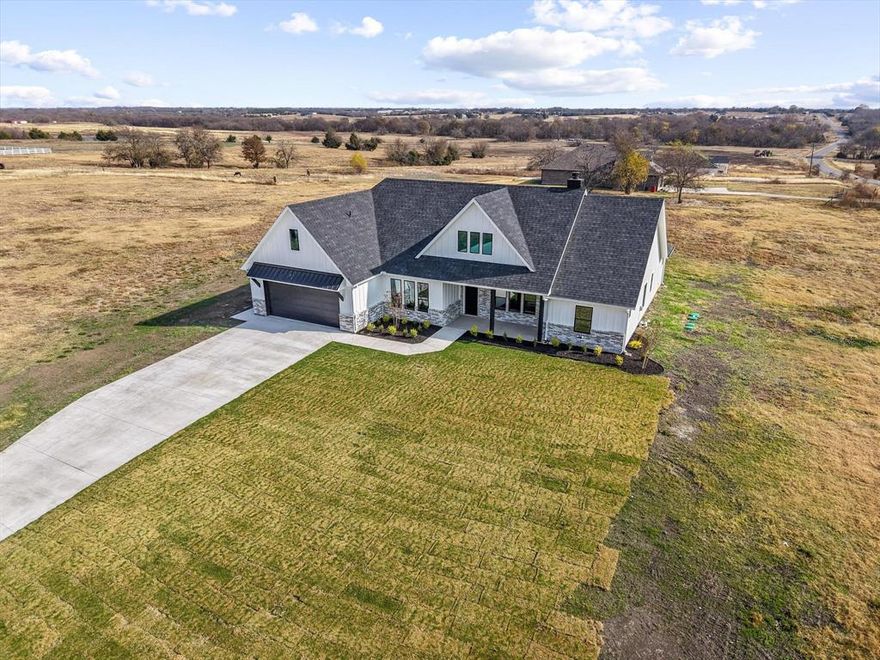 No HOA! No PID! No Mud! Welcome to this impeccable new construction home, a true testament to high-quality craftsmanship, located in Collin County & sought-after Blue Ridge ISD. Fall in love with this 1+ acre corner lot and the striking curb appeal of this contemporary craftsman, offering both space and privacy, with plenty of room to add a shop or a pool. The crisp, stark white board and batten siding and elegant brick exterior create a captivating contrast, accented by sophisticated rich black lighting & dramatic overhangs. This home is a true showstopper! Designed for a comfortable lifestyle, this unforgettable home boasts high-quality finishes and an open floor plan that is flooded with natural light. An airy & open ambiance is created by the expansive cathedral ceiling complemented by handsome wood beams. Enjoy the warmth and ambiance of the prominent fireplace (wood burning with propane starter). The heart of the home, this chef's kitchen is an entertainer's dream. Enjoy abundant storage with floor-to-ceiling soft close cabinetry, and a stunning, high-contrast island that serves as the perfect gathering spot. Kitchen flows seamlessly into the casual dining area. The backsplash is a work of art adding a bold contrast to the countertops. Primary BR showcases an incredible ensuite with dual vanities, soaking tub & a walk in shower that is magazine worthy. The home includes two additional bedrooms, another 1.5 bathrooms, versatile flex-office space, & large laundry room designed with added safe-space features in mind. Step outside to an expansive patio—perfect for entertaining or simply relaxing under those bright, starlit Texas nights. The home is generator-ready with electrical already installed & features a three-car tandem garage. This quality home is filled with desirable features & scenic views you’ll want to experience firsthand. Its exceptional location offers the perfect blend of country charm & everyday convenience.