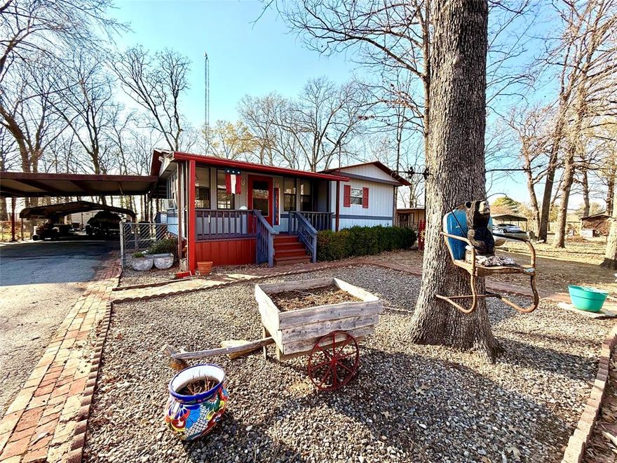 This a charming single wide home steps away from Lake Fork.  It features 2 bedrooms, 1 bath and a spacious addition that could be an awesome sun porch or office.  The kitchen is updated with beautiful cabinets and charming accents. The spacious yard has a 12x24 woodshop and an 8x16 storage building for tools and lawn equipment.  You can sit out back on the cozy porch swing and enjoy the sunsets from the serene back yard. There is ample space for your boat and cars with a potentially 6 car carport. Located on a charming cul-de-sc this would make an excellent short term rental or a cozy lake getaway.
