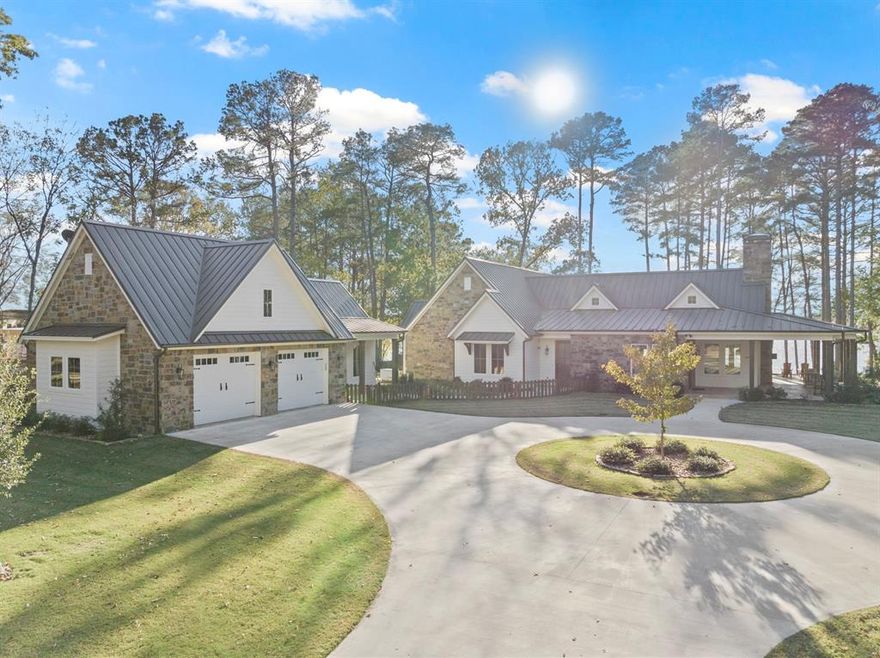 Discover your dream retreat in the pristine Lost Pines subdivision, where this stunning lakefront property spans nearly 1.5acres and boasts over 3,400 sq ft of luxurious living space. Built in 2023, this open-concept residence features beautiful engineered hardwood flooring, a striking stone fireplace, and two expansive kitchen islands equipped with top-of-the-line appliances. The lavish primary en-suite offers a serene oasis with breathtaking views featuring dual sinks, a soaking tub, a tile shower, and a spacious walk-in closet. Additional highlights include a detached guest house, a boathouse with slips for two jet skis and a ski boat, and a vast porch perfect for enjoying spectacular sunsets by the water's edge. Combining luxury, comfort, and nature's beauty, this home is not just a place to live; it's a lifestyle waiting to be embraced.