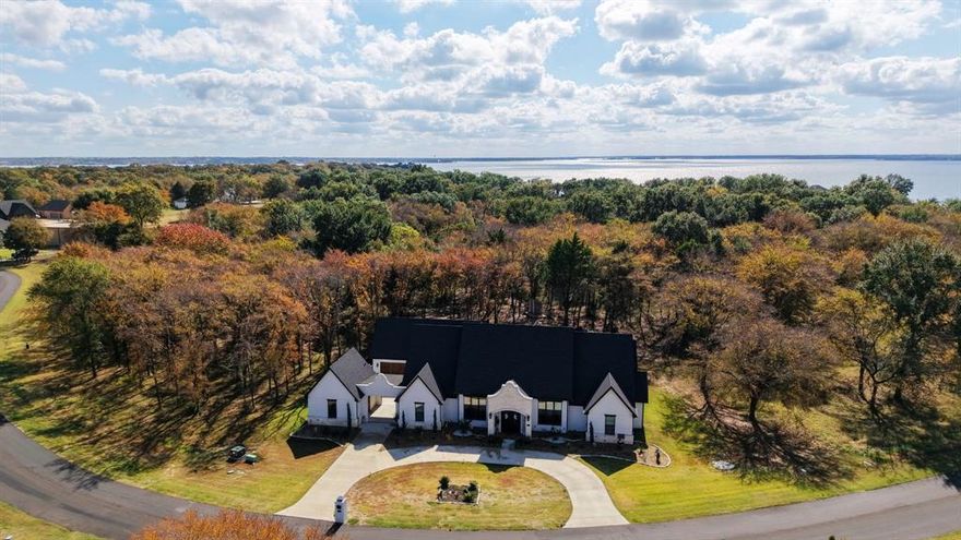 Stunning 2023 custom one-story home on a beautifully treed .72-acre lot in the gated waterfront community of Cedar Creek Landing! This newer neighborhood offers an amazing lake lifestyle with an infinity-edge pool, clubhouse, fitness center, boat launch, stocked fishing pond, day-use marina, golf-cart access to Cedar Creek Country Club (memberships available), city-maintained roads, fiber-optic internet, and fenced boat storage—ALL less than an hour from Dallas! Thoughtfully designed, this 3,120 sq. ft. property features a 2,800 sq. ft. 3-bedroom, 2.5-bath main house with game room plus a private 320 sq. ft. 1-bedroom, 1-bath guest suite—ideal for multigenerational living or weekend visitors. Both the living area and primary suite open to the screened porch across the back of the home, creating a wonderful indoor-outdoor extension. The cedar-finished gazebo offers space for grilling and gatherings, and the stone firepit area provides more opportunities for outdoor living. Inside, enjoy travertine floors throughout (no carpet), vaulted ceilings with wood-beam accents, and an open-concept kitchen and living area with a large island, black stainless appliances, a range with oven plus separate wall oven, built-in microwave, and oversized pantry. The primary suite includes a luxurious soaking tub, double-entry walk-in shower, generous walk-in closet, and peaceful backyard views. Bedrooms 2 and 3 share a Jack-and-Jill bath with separate vanities, and the half bath opens directly to the screened porch—perfect for entertaining and everyday convenience. Additional highlights include a tankless water heater, large floored attic storage, sprinkler system with well-designed French drain, transferable lifetime foundation warranty, and a nice laundry room with large stainless sink. Store your boat in the community’s fenced storage area and launch at the neighborhood ramp with day-use slips.