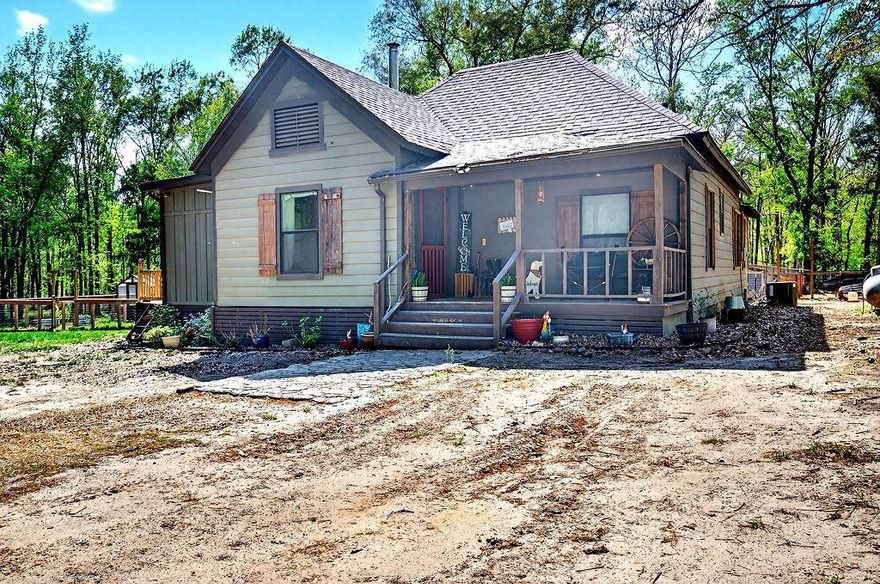 Located just outside the city limits, this 7.75-acre property offers the perfect blend of privacy, income potential, and room to grow. The land features a beautiful mix of woods and open areas, along with a spring-fed pond that adds both charm and functionality. The spacious main home has been recently updated and is currently income-producing as a rental. Improvements include a new roof (2020), 460’ deep well (2020), Hardiplank siding and new windows (2021), a wood-burning hearth (2022), and a bedroom and bathroom addition (2023). Additional upgrades include a detached 16’x24’ garage (2024), fenced garden with cedar greenhouse (2024), and a new air conditioner (2024). A newly constructed tiny home, currently operating as a short-term rental, provides excellent flexibility for additional income, guest accommodations, or multi-generational living. Completed in 2024, it features all new construction and appliances, plus major infrastructure updates including new electric service, waterline, aerobic system (2025), propane tank and lines, fencing, and a newly poured driveway (2025). With multiple living spaces, strong rental potential, and plenty of room to build or expand, this property is ideal for investors, homesteaders, or anyone seeking a private country setting with modern conveniences already in place.