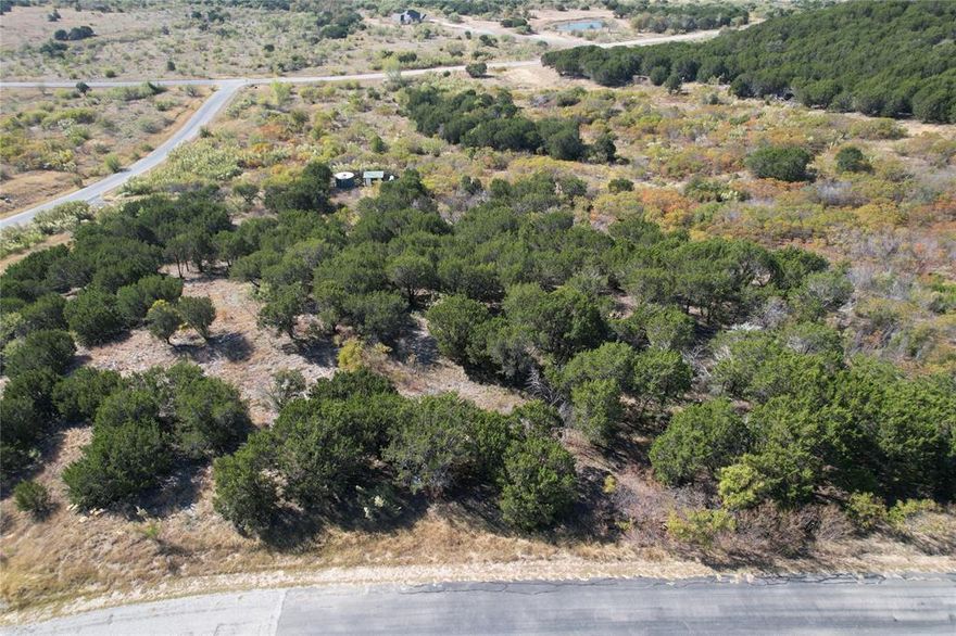 One acre lot overlooking the south end of The Hills and neighboring ranches. Panoramic view of the countryside from an elevated position. This lot is ideal for a home that is nestled into the woods but has a fantastic view. Lot ownership permits the use of all of the neighborhood amenities including clubhouse with pool and fitness center, boat storage, cabin with picnic area, community dock, boat ramp, lakefront area, fishing pond, and twenty miles of private roads behind the gates.