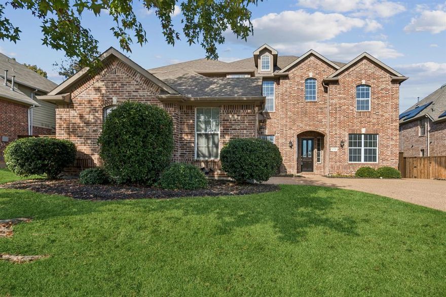 Welcome to this beautiful brick two-story home nestled in the highly sought-after Wellington community of Flower Mound. This well-maintained residence offers an inviting blend of comfort, functionality, and timeless design. The primary bedroom is conveniently located on the first floor and features a spacious sitting area, an ensuite bath with dual sinks, a separate tub and shower, and a generous walk-in closet. Upstairs, you’ll find three additional bedrooms along with a versatile loft or gameroom—perfect for studying, relaxing, or entertaining. The main living area boasts wood floors, a vaulted ceiling, a cozy gas log fireplace, a ceiling fan, and a serene view of the private backyard. Just off the entry is a dedicated office with French doors, ideal for working from home. The kitchen is thoughtfully designed with granite countertops, a tumbled-stone backsplash, a gas cooktop, a butler’s pantry, an island, a breakfast bar, and an open layout that flows seamlessly into the living area. Enjoy the charm of a covered front porch and the convenience of a two-car swing garage. Decorative light fixtures throughout the home add warmth and character. The large backyard offers ample privacy, lush landscaping, and plenty of space for outdoor living. Located in a premier neighborhood with excellent amenities, this home truly has it all—style, space, and an exceptional location.