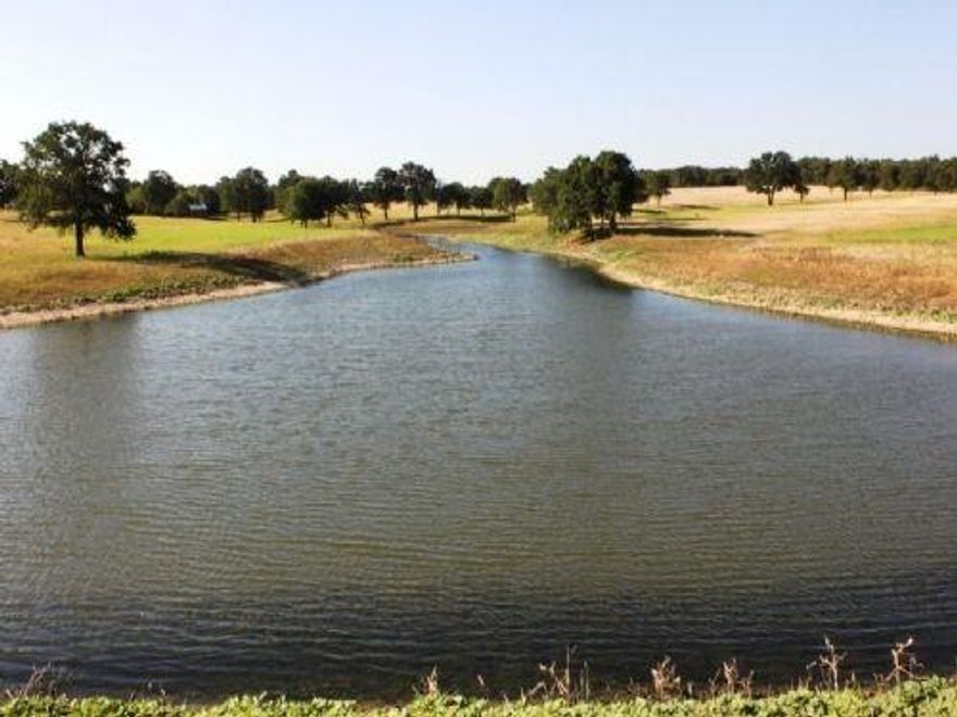 OWNER FINANCING at 4.5% Experience this One of a kind, Pristine 238.87-acre ranch with covered bridges, stone bridges, stone gated entrance, winding roads, 6 ponds with fish, premium Coastal Bermuda hay, native grasses, large Oak trees, crossed fenced in 40-acre sections, corrals, pens and outbuildings along with 4 water wells. A magnificent 4800 sqft wedding venue of Cedar & stone, Douglas Fir beams, chandeliers, bathrooms and kitchen with 800 sqft patio could serve as a luxury ranch house, corporate retreat, hunting compound, church retreat, concert venue, deluxe RV park, wellness facility or luxury getaway. A large, covered pavilion with stone fireplace provides beautiful vistas. Living quarters of a barn-dominium features open concept with cathedral beam ceiling, custom cabinets, granite countertops, and wood floors with attached 1800 sqft garage. Other features include 2450 sqft equipment shed. One of the most spectacular ranches around. This is for an entrepreneur with vision.