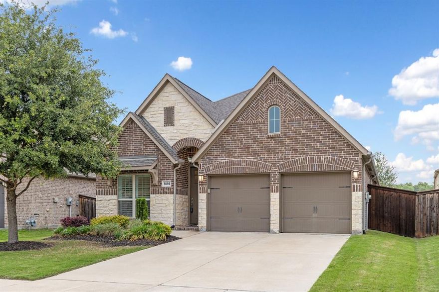 Designed to perfection, this stunning Trinity Falls single-story home delivers a seamless blend of elegance, comfort, and modern sophistication. Surrounded by over 450 acres of natural open space, scenic hike-and-bike trails, parks, lakes, and vibrant community gathering spaces, this home offers the perfect blend of comfort, convenience, and lifestyle just minutes from historic downtown McKinney. Inside, soaring ceilings and abundant natural light create an open, airy feel throughout the thoughtfully designed 3-bedroom, 2-bath layout with a dedicated home office behind elegant glass French doors. Stylish upgrades include wood-look tile flooring, shutter blinds throughout, 8-foot doors, LED lighting, and ceiling fans in every room. Centered in home, the chef inspired island kitchen is designed for both everyday living and easy entertaining, featuring quartz countertops, a gas cooktop, stainless steel appliances, custom wood vent hood, modern white backsplash, pot-and-pan drawers, and a breakfast bar for additional seating. The spacious primary suite offers a relaxing retreat with a spa-inspired bath complete with dual sinks, soaking tub, walk-in shower with seating, recessed shower floor, and a generous walk-in closet. Step outside to enjoy the covered patio with ceiling fan and TV prewiring, overlooking a fenced backyard with green space and a shade tree, ideal for morning coffee, evening relaxation, or hosting friends and family. Additional conveniences include a mudroom entry from the garage, utility room with folding area, garage storage shelving, full sprinkler system, and underground-terminating gutters. Kitchen refrigerator and utility room washer and dryer may also be conveyed with the home. Trinity Falls residents enjoy exceptional amenities including resort-style pools, fitness facilities, co-working spaces, dog parks, event lawns, playgrounds, community events, grilling areas, and welcoming gathering spaces designed to bring neighbors together year-round.
