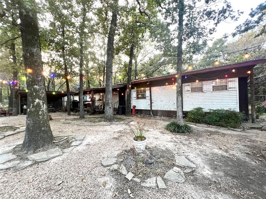 PRICED UNDER APPRAISED VALUE FOR INSTANT EQUITY! Welcome to your dream retreat! Nestled in a serene lake-view setting, this charming home offers a perfect blend of comfort and potential. Imagine waking up to stunning lake views and enjoying your morning coffee on the front porch. Or take it to your back porch, which adds approximately 420 sq ft of bonus space for relaxation or entertaining. The beautifully landscaped lot is dotted with mature trees, providing both privacy and a picturesque backdrop for your outdoor activities. With two gated entrances, accessing your property is convenient and secure. You'll also appreciate the workshop equipped with electricity, ideal for hobbies or additional storage. Whether you're looking to move in and make it your own or envision building your dream lake house from the ground up, this property presents endless possibilities. The home is being sold as-is, allowing you the freedom to explore your creative vision. Don't miss this opportunity to have your perfect lake-view oasis!