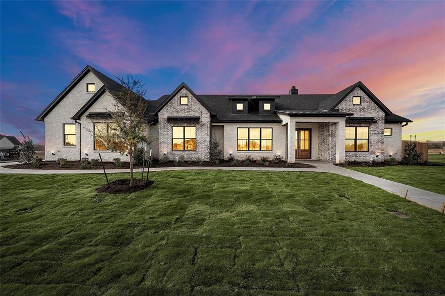 Experience the pinnacle of modern living in this immaculate, newly constructed residence. Spanning 3,403 square feet on a massive half-acre city lot, this architectural masterpiece offers a seamless blend of contemporary design and functional elegance. The open-concept floor plan centers around a chef-inspired kitchen equipped with premium appliances, custom cabinetry, and an expansive center island. Ideally designed for entertaining, the kitchen flows effortlessly into a dedicated bar area complete with a wine cooler. Unique dual-entry swivel doors lead into a massive pantry, which houses a discreetly hidden storm cellar for ultimate peace of mind. For those working remotely, a secluded home office provides a quiet and private workspace away from the main living areas. The great room is anchored by a dramatic floor-to-ceiling smeared stone fireplace, flanked by custom built-in cabinetry. This space transforms completely with a four-panel glass expanse door system that opens fully, blurring the lines between indoors and outdoors. Step out onto the expansive covered back patio, featuring elegant wood tray ceilings and a full outdoor kitchen with a built-in grill—the perfect setting for al fresco dining. The residence features five generous bedrooms and four and a half spa-like bathrooms. The primary suite serves as a true retreat, offering two separate walk-in closets and a luxurious bath with split dual vanities and a soaking tub. The attention to detail extends to the garage, which features a durable epoxy floor coating for a polished look and long-lasting protection. With ample parking for guests and extensive outdoor space rare for the city, this home checks every box. Don’t miss the opportunity to be the first to own this exceptional property.