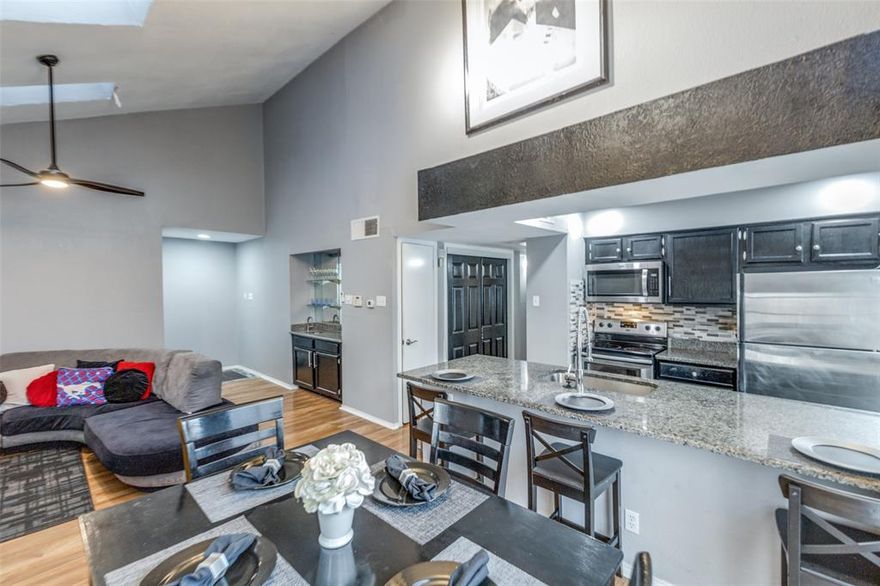 This two-bedroom, two-bathroom condo in Vickery Village features high ceilings, wood flooring, and a living area centered around a wet bar and natural light from overhead skylights. The updated kitchen, finished with granite countertops, sleek cabinetry, and stainless steel appliances, opens to a separate dining area and living room with access to a private balcony. The layout includes a dedicated laundry room for a full-size washer and dryer, while the primary suite offers an oversized closet with integrated attic storage access. Located minutes from US-75, Park Ln, Northpark and Walnut Hill rail stations, this property provides a functional floor plan and a strong investment opportunity in a highly accessible Dallas location.