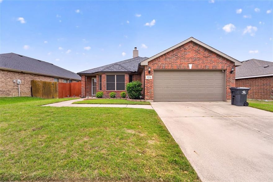 This single-story 3-bedroom, 2-bath brick home features a traditional exterior, a two-car garage, and a concrete driveway. A concrete walkway leads to the front entrance, which is protected by a glass storm door. The roof is composed of composition shingles, and the exterior is finished in brick with a wood-burning fireplace chimney.

The interior layout includes a spacious living room with wood flooring and a fireplace with a mantel and tile surround. The kitchen is equipped with cabinetry, countertops, and stainless steel appliances, including a microwave and electric range. A dedicated utility room off the kitchen provides space for laundry and includes built-in pantry shelving. The primary bedroom is finished with carpet and an ensuite bathroom that contains a double vanity, a garden tub, a separate shower, and a walk-in closet with built-in shelving.

Two additional bedrooms feature carpet and ceiling fans. One secondary bedroom includes a bay window overlooking the street, while the second bedroom has a window facing the side yard. These rooms share a full bathroom equipped with a tub-and-shower combination and a vanity.

The backyard is fully enclosed by a privacy fence and a wrought-iron fence, providing views of the community pond located directly behind the lot. A large covered concrete patio includes a ceiling fan, and the yard features a mature tree along with a stone-bordered planter bed. This location is a few minutes away from Don Misenhimer Park, Bowman Branch Linear Park, Webb Community Park, Imogene Gideon Elementary School, and James L. Coble Middle School.