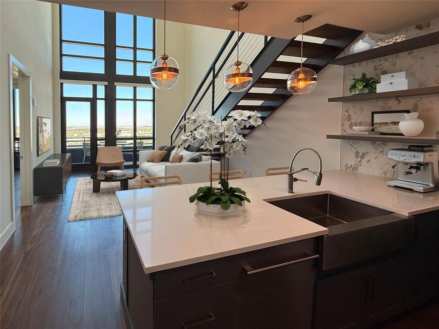 Experience luxury high-rise living in this top-floor penthouse residence at The Aster Turtle Creek, ideally located at 3611 Congress Avenue in the heart of Dallas. Offering approximately 1,402 square feet with two bedrooms and two full bathrooms, this modern two-story home features dramatic double-height ceilings, floor-to-ceiling windows, and an open, light-filled layout that captures sweeping skyline and Turtle Creek views. The design combines contemporary architecture with timeless materials, emphasizing livability and style. The main level centers around a chef-inspired kitchen outfitted with Sub-Zero and Wolf appliances, custom blue cabinetry, quartz countertops, and a waterfall island with farmhouse sink, open shelving, and pendant lighting. The open-concept floor plan connects seamlessly to the dining and living spaces with warm wood flooring and abundant natural light. A steel-and-wood staircase leads to the loft-style second floor - perfect for a home office, media room, or living room - overlooking the main living area. The primary suite offers a private retreat with electric shades, generous walk-in closet, and a spa-style bath with dual vanities, soaking tub, and glass-enclosed shower. The secondary bedroom provides flexibility for guests or workspace with an adjacent full bath. A large private balcony extends the living area outdoors for enjoying Turtle Creek and Uptown views. Residents enjoy premier amenities including a rooftop lounge, resort-style pool with waterfall feature, two-story fitness center, yoga deck, golf simulator, concierge service, pet-bathing station, and private gated garage with EV-ready spaces and guest parking. Ideally situated near the Katy Trail, Turtle Creek Park, Uptown, Oak Lawn, and Downtown, this residence offers a refined lifestyle of design, comfort, and convenience. Lease $5,277 per month with promotional incentives available; immediate occupancy.