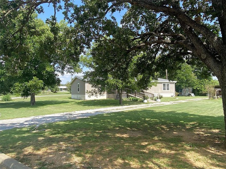 This beautifully maintained 2013 manufactured home offers the perfect blend of space, comfort, and functionality—all nestled on a generous 0.5+ acre lot shaded by mature pecan trees. Boasting 2,210 square feet of open-concept living, this 3-bedroom, 2-bathroom home features two spacious living areas, one with a cozy wood-burning fireplace and the other with a built-in entertainment center—perfect for relaxing or entertaining guests.

The primary suite is a true retreat, offering a huge walk-in closet and a luxurious ensuite bathroom complete with a jetted tub, separate shower, and dual vanities. The two additional bedrooms are connected by a convenient Jack and Jill bathroom with dual sinks and a tub and shower combo. A dedicated home office provides ideal space for remote work or study.

The kitchen is a standout, with abundant cabinet space, kitchen island, pantry, and plenty of room to cook and gather. Outside, enjoy the large covered back porch with ramp access, a 4-car carport, and big beautiful pecan trees.

Recent upgrades include a new roof, offering peace of mind for years to come. This home combines country charm with modern conveniences—don't miss your chance to make it yours! **Bonus** Sellers are offering $5,000 in concessions to help with any repairs that may be needed.
