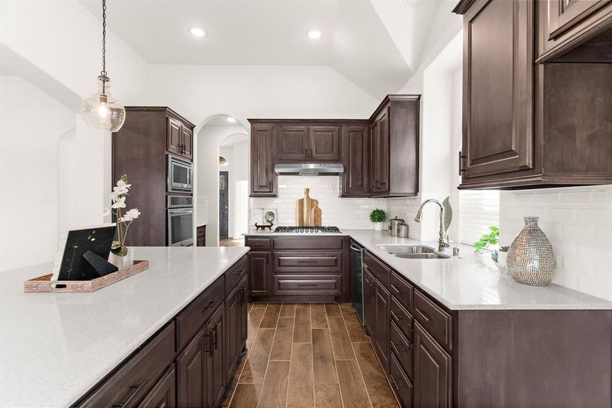 This stunning, immaculate single-story home with 4 BEDS + OFFICE + FORMAL DINING by First Texas Homes boasts a highly customized Sonoma floorplan with UPGRADES GALORE! Unlike any others, this customized floor plan includes an EXTENDED LIVING ROOM, EXTENDED COVERED PATIO, EXTENDED GARAGE, OVERSIZED PRIMARY, & more! Additional upgrades include soaring 11-ft ceilings, archways, new light fixtures throughout, and beautiful WOOD-LIKE TILE covering every square inch of the floor! A private home office with glass-pane French doors is ideal for work or study. The gourmet kitchen is a chef’s dream featuring DOUBLE OVENS, high-end Frigidaire Gallery appliances and 5-burner gas cooktop, upgraded island with cabinet storage, spectacular QUARTZ COUNTERTOPS, upgraded tile backsplash, upgraded walnut cabinetry with pot drawers, walk-in pantry & separate BUTLER’S PANTRY. Perfect for entertaining, the spacious living room boasts large windows offering natural light, and beautiful upgrades from the CROWN MOLDING to the STONE GAS FIREPLACE. The oversized primary suite is the perfect retreat with vaulted ceilings, bay windows, spa-like bathroom, & large walk-in closet. Secondary bedrooms have vaulted ceilings and generous closets. Smart home upgrades include whole-home industrial-grade WATER FILTRATION AND SOFTENER SYSTEM, TANKLESS WATER HEATER, whole-home CENTRAL VACUUM , Ecobee thermostat, ethernet to every room, HomePro security, Wi-Fi booster, and exterior camera. Backyard features an extended covered patio with fan and roller shade. Oversized 2-car garage w storage and side entry door. Zoned to award-winning Melissa ISD, located in the desirable Willow Wood neighborhood of McKinney with a pool, sport court, playground, and walking trails. Less than a mile from Willow Wood Elementary with quick access to Hwy 5, US-75, and 121, minutes from HEB, BUC-EE’S, retail, dining, parks, and more, don’t miss out and make this one-of-kind home yours today!