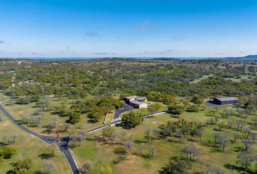 This 400-acre Hill Country ranch is located in highly desired Blanco County in the Cypress Mill area. Only 40 miles and less than an hour from Downtown Austin. Marble Falls, Johnson City and Horseshoe Bay are 15 minutes away. This stunning Texas ranch is one of the most desirable areas of the Hill Country.

This turn-key, unrestricted property is wildlife exempt, perfect for hunting, recreation, or potential event venue. With approximately 4,100 feet of frontage along RR 962 E and only 3 miles east of Hwy 281, the ranch offers excellent access and privacy. Upon entering, you will feel like you are entering a park, with a paved road winding through maintained grounds and hundreds of majestic live oaks. The ranch features dense wooded areas as well offering great habitat for wildlife. The rolling hills provide incredible breathtaking views. Partially high fenced on two sides, the ranch boasts two large lined ponds that remain full year-round.

The main residence spans 4,800 square feet and features six bedrooms, eight bathrooms. With hardwood floors, top-of-the-line appliances, and high-end finishes throughout, this home is perfect for entertaining family and friends. The luxury outdoor entertaining area includes a heated pool with a built-in cover, an outdoor kitchen, along with an outdoor fireplace.

In addition to the main residence, there is a well-appointed insulated barn approximately 5,500 sqft. The barn has three separate air-conditioned spaces including a full office with bathroom and an apartment, perfect for a ranch hand or full-time foreman.

The ranch is equipped with off-grid capabilities with 70% of the house running off solar energy. Also boasts 90,000 gallons of rainwater collection, the ranch features three wells that produce 20-30+ gallons per minute.