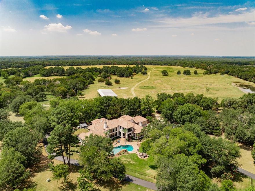 Minutes from downtown Dallas, this Premier 125.9 acre Gentleman's Ranch offers privacy and seclusion in style, with every modern amenity. Located in sought after Poetry, TX, this furnished luxury gated estate boasts a tastefully updated 6,566 sq. ft. mansion, complete with library, exercise room, game room, and media room, updated gourmet kitchen, large family room and elegant dining room, designed for luxury living, alongside a beautiful outdoor pool with spa and fire pit overlooking one of 2 large ponds. The estate features a completely renovated three-bedroom, two-bath farmhouse, a greenhouse, 2 barns and a large workshop building with RV and boat storage, recreation room and air-conditioned storage, offering ample space for various needs. The property is fully fenced and cross-fenced, with lush pastures, 2 ponds and 4 tanks, wooded areas, a small bunk house with AC, and well-maintained trails. Enjoy privacy with a gated entrance on a private road and additional adjoining acreage on a county road. Ideal for primary home, ranch retreat or recreational pursuits. This ranch is the only move in ready 100+ acre property available east of Dallas within commuting distance to downtown. Possible Owner Financing with favorable terms available with approved credit. Leave the world behind in style.