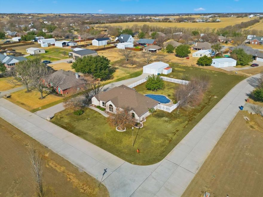 Welcome to 2501 Caddo Trail in Sanger, TX! This beautifully updated 3-bedroom, 2-bathroom home offers 2,472 sq ft of comfortable living space with all new floors and paint throughout. Sitting on a 0.875 acre corner lot in a quiet, established HOA FREE neighborhood, this home has so much to offer. Built in 1997, this well-maintained property features a flexible layout with two living and dining areas. The kitchen offers ample cabinetry, new granite countertops and backsplash as well as a breakfast nook. The primary suite boasts an updated en-suite bathroom and two walk-in closest. On the other side of the home you will find two additional bedrooms and a second full, updated bathroom. A dedicated laundry room adds convenience to daily living as well as a half bath off the second living area with easy access to the pool. Step outside to a covered patio overlooking a private in-ground pool and large fenced yard. The back of the property has a 40x30 shop with electricity and water nearby. The shop has two roll up doors as well as custom shelving and work benches. With recent updates throughout including, LVP and paint (2026), new windows, granite and carpet (2025), a new AC system (December 2024), as well as a durable brick exterior, a pool, large yard, shop and no HOA, this home combines comfort, functionality, piece of mind and freedom. Located in sought-after Sanger ISD with quick access to I-35, it’s a perfect blend of small-town charm and everyday convenience!