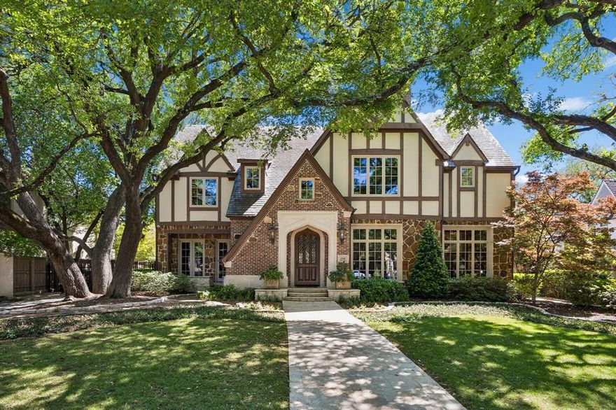 Situated on an impressive 90-foot lot in the heart of the French Streets, this gorgeous Tudor-style residence built by Tatum Brown offers an exceptional blend of architectural distinction and timeless craftsmanship. Surrounded by mature live oak trees, the home features a stunning entry and staircase complemented by exquisite moldings, detailed millwork, and hand-scraped hardwoods.  The main level includes a formal living room with a striking stone fireplace and a dining room with a 300-plus bottle wine closet. Designed for entertaining, the open kitchen comes with stainless Viking appliances, granite countertops, island, built-in refrigerator, and a walk-in pantry. A breakfast room and wet bar flank the kitchen. French doors lead to a loggia overlooking a pool and spa surrounded with Oklahoma flagstone. Completing the first floor are a guest bedroom, full bath, and an impressive office with beautiful coffered ceilings and views of the front yard.  The second level houses a very spacious and luxurious primary suite with a sitting area—suitable for a study or nursery—and a covered balcony overlooking the pool. The primary bath includes separate vanities with marble countertops, an oversized marble shower, and his and her walk-in closets. All secondary upstairs bedrooms feature ensuite bathrooms and walk-in closets, while a third-floor media room offers flexibility as a sixth bedroom.  Additional highlights consist of a three-car garage with quarters above and a cabana with full bath, providing an additional 958 square feet. High-end details and amenities such as a slate roof, copper gutters, porte-cochere, electric gate, laundry room, mud room, elevator, and covered outdoor kitchen round out this remarkable property.