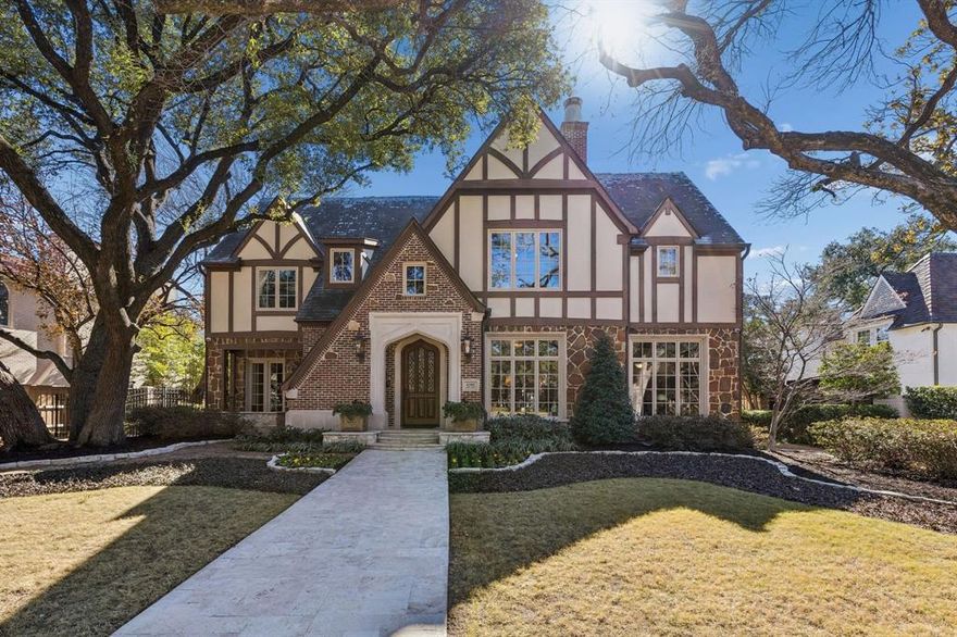 Situated on an impressive 90-foot lot in the heart of the French Streets, this gorgeous Tudor-style residence built by Tatum Brown offers an exceptional blend of architectural distinction and timeless craftsmanship. Surrounded by mature live oak trees, the home features a stunning entry and staircase complemented by exquisite moldings, detailed millwork, and hand-scraped hardwoods.  The main level includes a formal living room with a striking stone fireplace and a dining room with a 300-plus bottle wine closet. Designed for entertaining, the open kitchen comes with stainless Viking appliances, granite countertops, island, built-in refrigerator, and a walk-in pantry. A breakfast room and wet bar flank the kitchen. French doors lead to a loggia overlooking a pool and spa surrounded with Oklahoma flagstone. Completing the first floor are a guest bedroom, full bath, and an impressive office with beautiful coffered ceilings and views of the front yard.  The second level houses a very spacious and luxurious primary suite with a sitting area—suitable for a study or nursery—and a covered balcony overlooking the pool. The primary bath includes separate vanities with marble countertops, an oversized marble shower, and his and her walk-in closets. All secondary upstairs bedrooms feature ensuite bathrooms and walk-in closets, while a third-floor media room offers flexibility as a sixth bedroom.  Additional highlights consist of a three-car garage with quarters above and a cabana with full bath, providing an additional 958 square feet. High-end details and amenities such as a slate roof, copper gutters, porte-cochere, electric gate, laundry room, mud room, elevator, and covered outdoor kitchen round out this remarkable property.