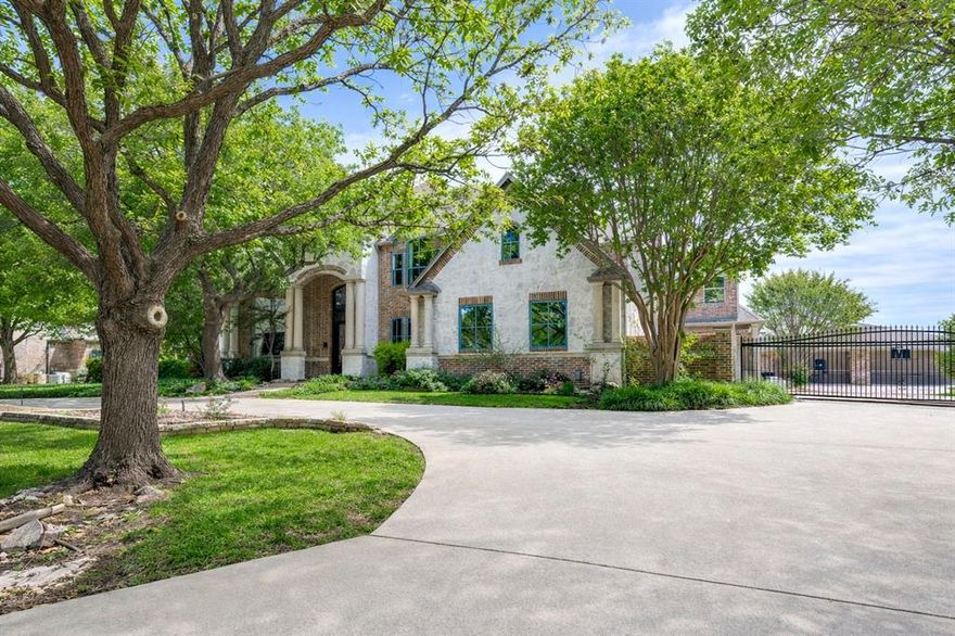 Located in the prestigious North Lake Woodlands community, this extraordinary custom estate offers exceptional design, luxury finishes, and unmatched functionality. A grand circular drive and gated motor court introduce the home, complemented by a seven-car garage, including four air-conditioned bays with high-end flooring, kitchenette, and bath. Inside, a breathtaking two-story entry with a sweeping staircase and rich hardwood floors sets the tone. Elegant formal living and dining spaces showcase refined details, while a beautifully designed study features custom built-ins, a window seat, and abundant natural light. The expansive kitchen is a true showpiece, designed for multiple chefs with an oversized island, commercial-grade cooktop with vent hood, warming drawer, beverage fridge, and Thermador appliances, opening seamlessly to a bright living area and spacious breakfast room. The private first-floor primary suite offers serene backyard views and a fully remodeled spa-inspired bath and dressing room. A secondary bedroom with full bath and private exterior access adds flexibility. Upstairs, three generously sized bedrooms each include en suite baths, along with a large game room featuring a wet bar and balcony, plus an impressive media room. Outdoor living is equally exceptional with a resort-style pool and spa with rock waterfall, outdoor kitchen, and cabana with bath, all surrounded by lush landscaping for ultimate privacy. Award-winning Coppell ISD.
