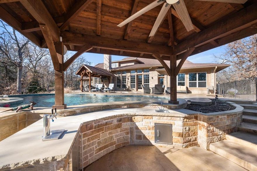 Recent upgrades include fresh interior repaint, updated bathrooms, updated light fixtures, and more. Experience lakeside luxury in this 5,524sf home on 1.3ac of waterfront bliss. Step into a welcoming lodge-like atmosphere accentuated by a large open living area with a striking stone fireplace. Outside, a spacious pool and entertainment area beckon for family gatherings amidst panoramic lake views. The 2019-built backyard oasis boasts a 2,200 sq ft patio, a pool with a swim-up bar, a hot tub, equipped outdoor kitchen. Gourmet kitchen featuring a 9'x 5' pantry and 47 cabinets. Retreat to the main bedroom with sizable his & hers walk-in closets. Storage abounds with two walk-out attics, a lg laundry room w built-in cabinets. Added in 2022, a home generator ensures uninterrupted comfort. Embrace eco-friendly living with a high-efficiency geothermal system and private well with city water backup. Don't miss out on this exceptional lakeside lifestyle opportunity!