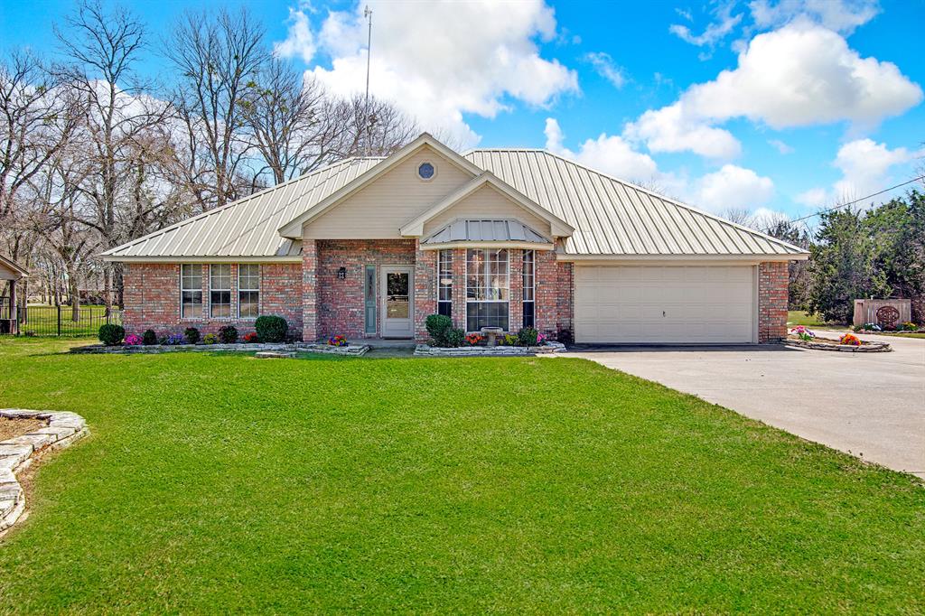Bring All Offers Motivated Sellers! A Texas dream home in a prestigious gated lake resort community. Live life to the fullest at the marina fishing and boating on Lake Whitney or play a round or two on the two lush green golf courses. Or sunbathe pool side at the resort style swimming pools. Host a party at the community center, enjoy pickleball and tennis at the courts, grab a drink at the Waterfront pub, and so much more that this resort community offers.  Come sit on the 23x12 back deck or around the custom fire pit on a Texas chilly night or cast your line in the creek at the back of the property that is spring fed. This home offers a relaxing atmosphere and charm as soon as you walk in the front door.  Who doesn't love custom stained solid wood knotty alder cabinets, these gorgeous cabinets are throughout the home. Cook your meals in this beautiful chef's kitchen with granite countertops, a farmhouse sink, custom lighting, built in microwave and KitchenAid convection oven, a 36 inch gas cooktop, a breakfast room, oh my, the storage this kitchen offers. The house offers hand scrapped hardwood floors, beadboard, shiplap, 6 inch floor trim, a gas hot water heater and heater, beautiful tray ceilings, dual sinks in the primary bathroom, a walk in shower and closets, a large flex room off of the living room and kitchen, a formal dining room, or can be used as an office, with custom lighting and wall treatments. A huge utility room that comes with a fridge, a sink, a huge pantry and room for a full size washer, dryer. The brick wood burning fireplace with gas start is the focal point in the living room. A gun safe is tucked away in a closet, An updated panel box and workshops or an extra garage with electricity and a metal roof over the entire house. Come home to a slice of Texas and enjoy peaceful living at White Bluff Resorts at Lake Whitney. Seller is offering $5k towards buyers CC OR $5k towards a Decorators Allowance and up to $400 for a Home Warranty for 1 year.