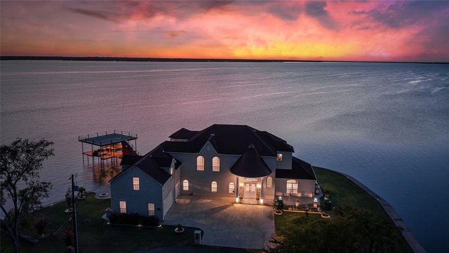 Imagine owning a breathtaking waterfront property on an open water peninsula with 363 feet of  shoreline— This incredible 4-bedroom home (plus office, which could also serve as a formal dining room or 5th bedroom) offers a lifestyle of luxury and relaxation, directly on the water at Cedar Creek Lake. Designed to take full advantage of the expansive views, the home features almost every room with stunning water vistas. You'll love the spacious, open floor plan with real wood floors, soaring 12-foot ceilings, and large windows that invite natural light and panoramic views throughout. The kitchen includes a large island with seating, granite countertops, and a wine refrigerator, perfect for entertaining or enjoying family meals. The main floor water side master suite offers a serene retreat with a gorgeous bathroom featuring double vanities, a separate tub, a walk-in shower with multiple heads, and a custom walk-in closet. Additional highlights include a bonus room for a second living area or game room, a media room or bunk room, and an oversized 3-car garage. Step outside to enjoy the screened porch with an outdoor kitchen with sink and oven or relax on the composite decked boathouse, which includes a party deck and covered sitting area, perfect for lakeside entertaining. Onduvilla roof, a waterproof clay tile look roof designed and guaranteed to withstand winds up to 150 miles per hour per the manufacturer.  in Gun Barrel City on Cedar Creek Lake, this home is just an hour from downtown Dallas, yet a world away from the hustle and bustle. With all the furniture, boat, and personal watercraft included, this home is truly a turnkey waterfront retreat!