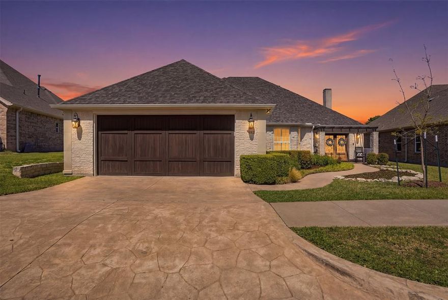 Welcome to this highly desirable, gated & quiet community of Reata West @ Team Ranch. Your luxury home awaits you! This one-story custom home beauty features an open concept layout, triple crown transom at front door, raised ceilings, crown molding, shutters, split bedroom arrangement, tile flooring & wood-look tile flooring, granite countertops, recessed lighting, arched & bullnose sheetrock, cedar beamed ceilings, upgraded lighting & hardware, chair railing, built-in hutch, gas log fireplace in large living room with stained cedar mantel & barn doors. The dining area doubles as a spacious home office or whatever fits your lifestyle. Gourmet kitchen features quartz island with breakfast bar, pendant lighting & undermount farm sink, wine cooler, granite countertops, tile backsplash, glass-front cabinets, stainless steel appliances including double wall gas ovens, gas cooktop, microwave, dishwasher, paneled & trimmed vent-a-hood & walk-in pantry, gutters, patio, wrought iron fencing, scored concrete, flagstone steps, sprinkler system & extensive landscaping. Primary, oversized bedroom with on-suite bathroom featuring a double-sided gas log fireplace, barrel ceiling, double vanities, separate walk-in shower & free-standing copper soaking tub plus walk-in, built-in closet. This large backyard is your relaxing escape! Serene oasis featuring a sparkling in-ground gunite pool with diving board, sun deck & raised spa with waterfall features. 2 car garage with floor epoxy & insulated overhead door & stamped concrete driveway. Additional guest parking located just steps away across the street. Enjoy your morning coffee or wind down your day in the enclosed porch courtyard complete with outdoor kitchen & wood-burning fireplace. Also, the perfect space to entertain! New gutters & roof in March 2026! Will be a perk when shopping for home insurance! Close to private schools. This is the true definition of unparalleled elegance adorned in picturesque surroundings. Welcome home!