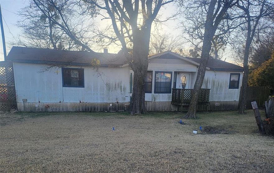 Double Wide on large corner lot right on the highway.  This house was once used for commercial purposes as a tire shop utilizing the large shop out back.  Most of the floors have been redone including the subfloors.  All appliances are staying with the house.  The owner is still doing minor repairs.  There are window units in each bedroom and in the living room along with central heat.  The house could use a little TLC.