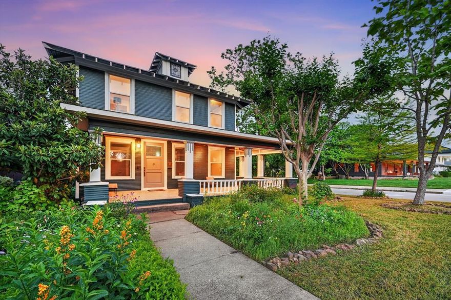 Charming 1918 historic home with over a century of character, blending timeless architecture with thoughtful modern updates, located just blocks from the Bishop Arts District and Kidd Springs Park. Showcasing where early 1900s charm meets Art Deco influence, the home features moody tones, vintage hardware, designer lighting, and curated details that create a soulful, one-of-a-kind atmosphere. Oversized living spaces begin with a moody listening parlor, flowing into a flexible dining area, library or flex space that can easily function as a guest room with access to a full bath. The open-concept kitchen and living area offer a warm, inviting layout ideal for entertaining. Rich in history, the home highlights preserved early 1900s craftsmanship—from original doors and molding to thoughtfully maintained finishes—seamlessly paired with modern updates. Upstairs features a large living area that can serve as an extension of the primary suite. Down the hall, guest quarters, full bath, bedroom, and a light-filled sunroom—ideal for a yoga or workout space. Picture sitting back on wrap around front porch and taking in the lush, established landscaping. Detached garage with loft and rear space offers potential for a studio, guest quarters, or creative retreat.
