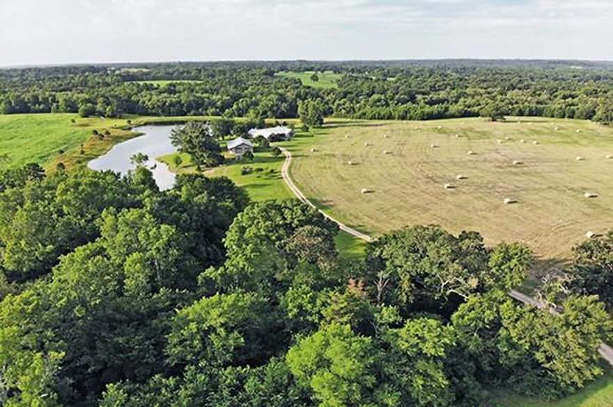 Wild Wings Farm is a turnkey family ranch built for family gatherings, hunting and recreation, grazing and hay production. 2904 Sq Ft (tax) custom stone ranch home, built 2015, overlooking a bass filled fishing lake. Adjacent stone shop, 1950 Sq Ft, with 4 roll up doors, full bathroom, and loft with substantial storage. An additional 10 bodies of water throughout the ranch. Mix of maintained productive meadows and heavily wooded areas of primarily Oak. Meadows are appx 60% Bermuda and 40% Bahia. 2nd barn of 2400 Sq Feet with 2 roll up doors and covered concrete exterior pads. Controlled access automatic main entrance gate. 4 sides frontage totaling appx 3.7 miles including Highway and County Rd frontages and an extensive internal trail system which combined allows access to any point on the ranch. 4-4 ranch home with split design floorplan for large family - friend gatherings. Wood grain ceramic tile throughout. Vaulted ceil great room with WBFP. 2 car garage.