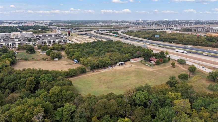 Explore a premier commercial development opportunity on a 5.9-acre estate in Grand Prairie, strategically located on East Bound Frontage Road. This property offers a versatile 2,350 sq ft brick building, perfect for conversion into office space, and includes a separate 4-car garage or shop, a tractor shed, and a barn. The site features a private well with city water backup, high-speed fiber internet, and over 300 feet of highway frontage, the property is fenced at the road with a new wrought iron fence and automatic gates. With its Dallas County tax roll status and proximity to DFW International Airport, downtown Dallas, and Fort Worth, this location is ideal for various commercial ventures. Its rich, fertile land and existing infrastructure make it a promising investment in a high-growth corridor. The city has previously said that they will not allow apartments or hotels here so the ideal use would be general commercial, an event venue or light industrial. The property is currently zoned SFR but is zoned for General Commercial once SFR use is no longer is use. A portion of the property is flood plain and is priced accordingly; agent has survey available.